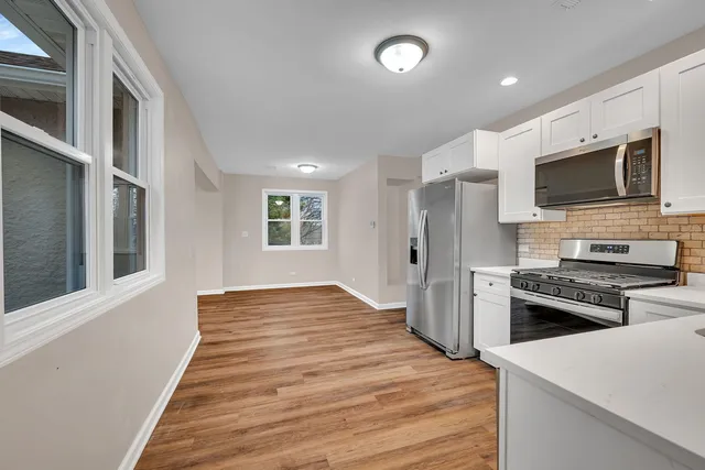 a kitchen with stainless steel appliances kitchen island granite countertop a refrigerator stove and sink