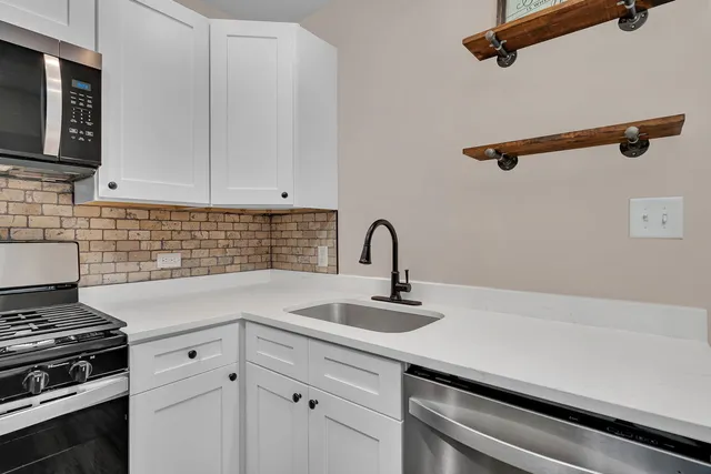 a kitchen with a sink stainless steel appliances and cabinets