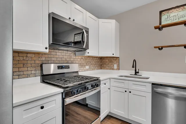 a kitchen with cabinets appliances and a sink