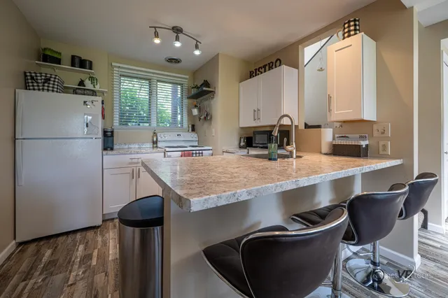 a kitchen with a table chairs sink and cabinets