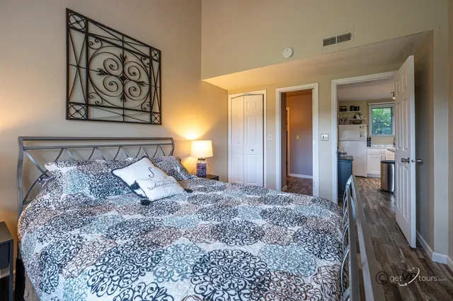 a bedroom with a large bed and a chandelier