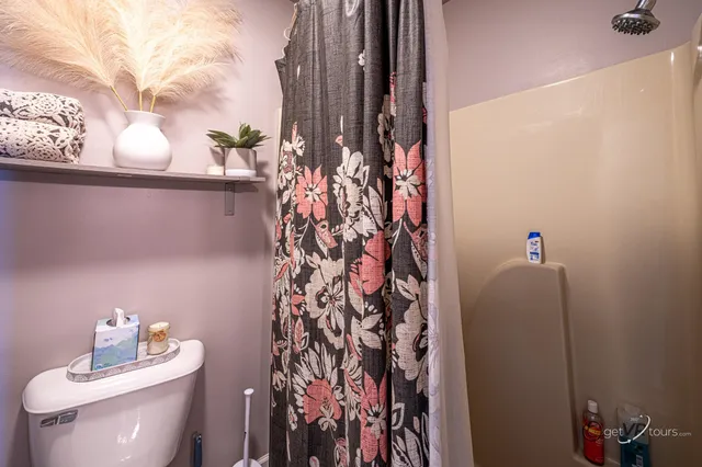 a bathroom with a toilet and shower curtain