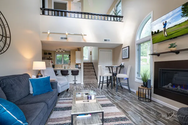 a living room with furniture a fireplace a rug and a window