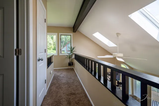 a view of a hallway with wooden floor and stairs