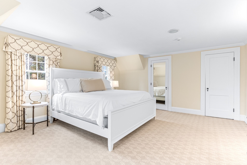 409 Heath Street Brookline, MA 02467 - Photo 14 of 29 a bedroom with a bed lamp and a large window