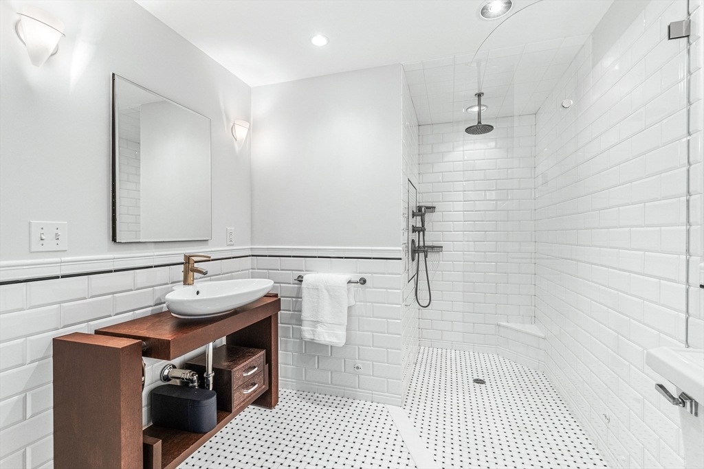 409 Heath Street Brookline, MA 02467 - Photo 15 of 29 a bathroom with a sink and a mirror