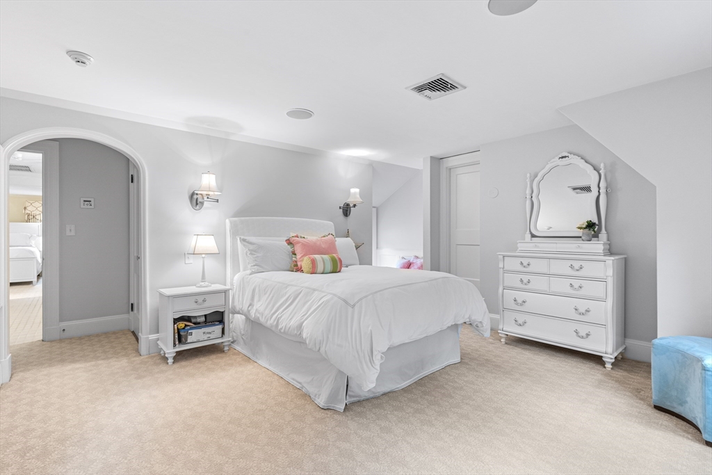 409 Heath Street Brookline, MA 02467 - Photo 16 of 29 a bedroom with a bed a dresser and mirror