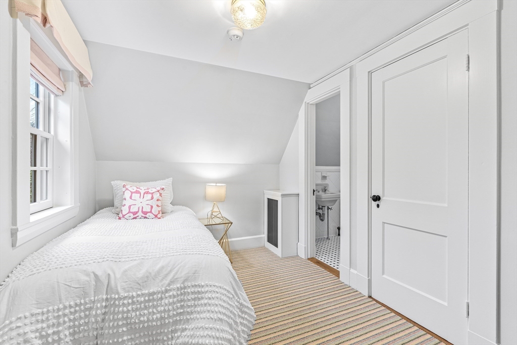 409 Heath Street Brookline, MA 02467 - Photo 19 of 29 a bedroom with a bed and a chandelier