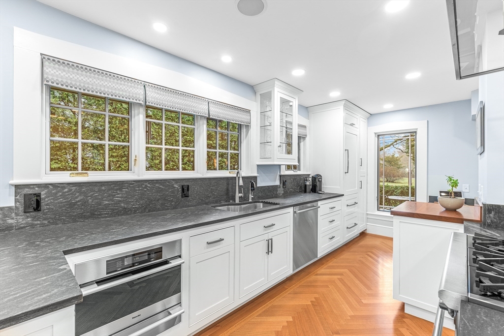 409 Heath Street Brookline, MA 02467 - Photo 10 of 29 a kitchen with granite countertop a sink and white cabinets