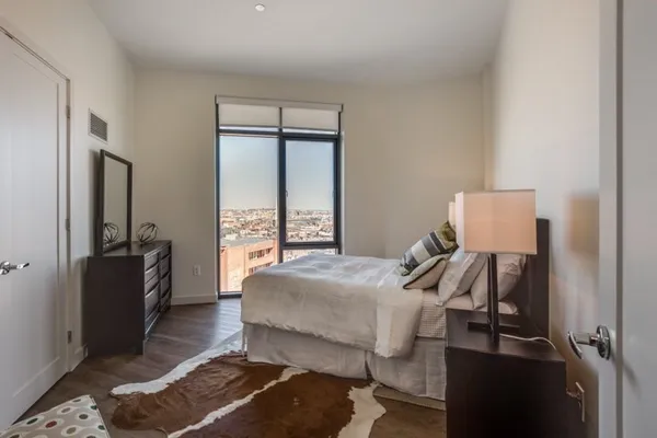 a bedroom with a bed and wooden floor