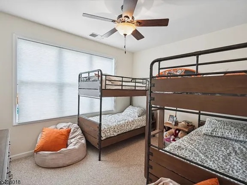 169 Tarrington Road, Unit 203 Hamburg, NJ 07419 - Photo 12 of 15 a bedroom with a bed and a chandelier