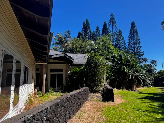 a view of a house with backyard and sitting area