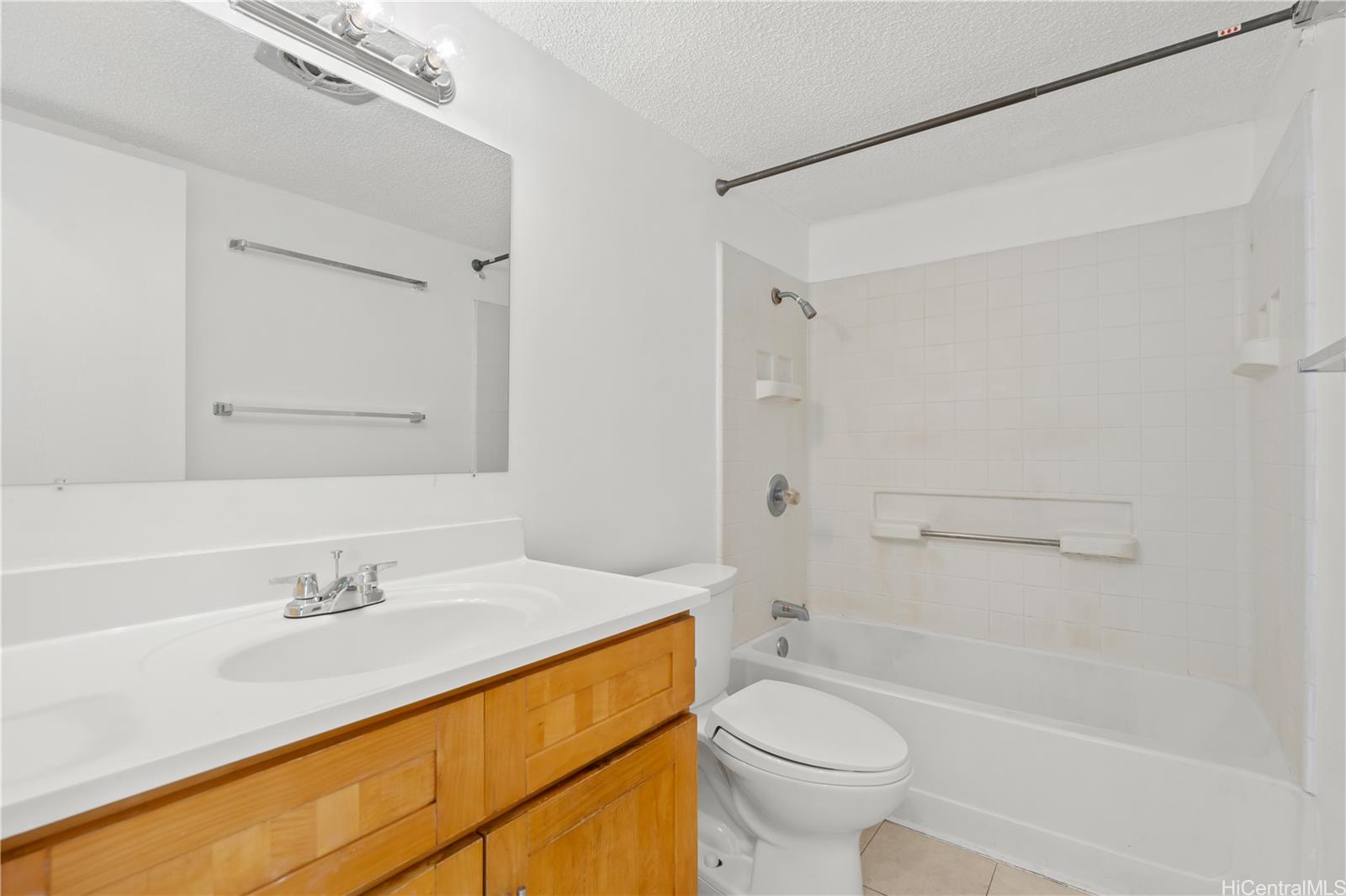 98-1042 Moanalua Road, Unit 2201 Aiea, HI 96701 - Photo 11 of 19 a bathroom with a sink a toilet and a bathtub
