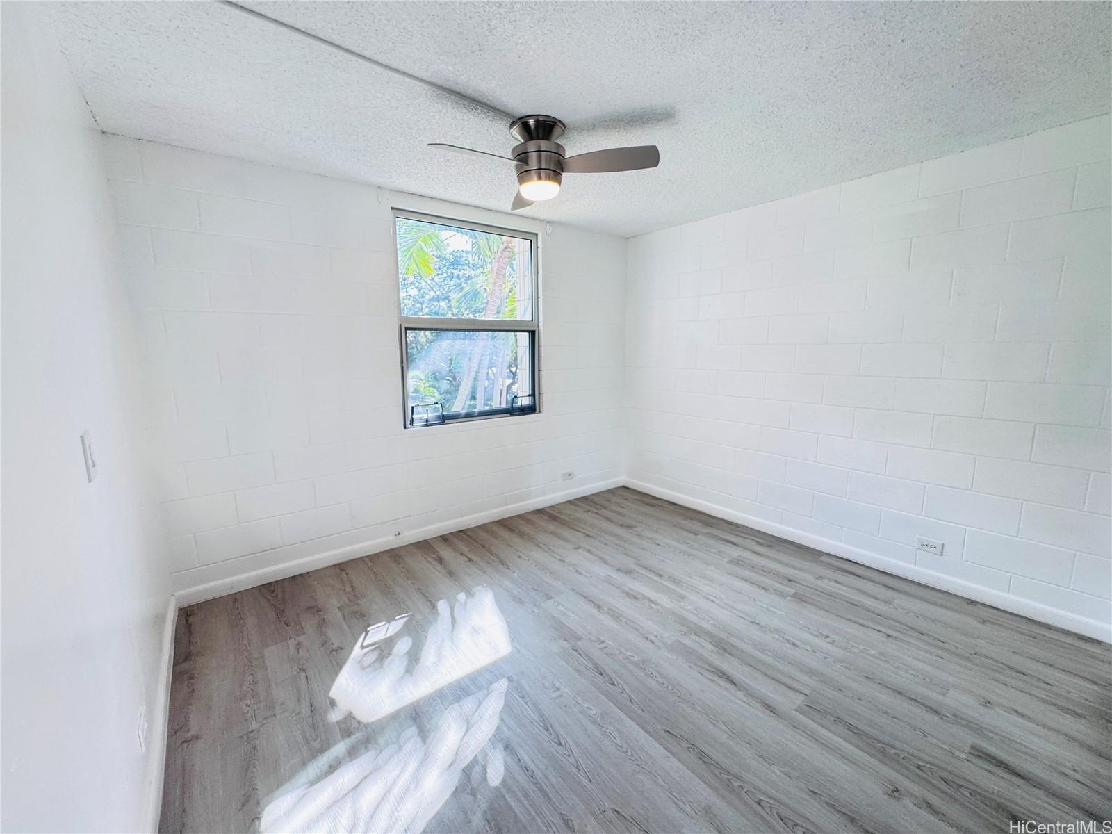 98-1042 Moanalua Road, Unit 2201 Aiea, HI 96701 - Photo 8 of 19 an empty room with wooden floor and windows