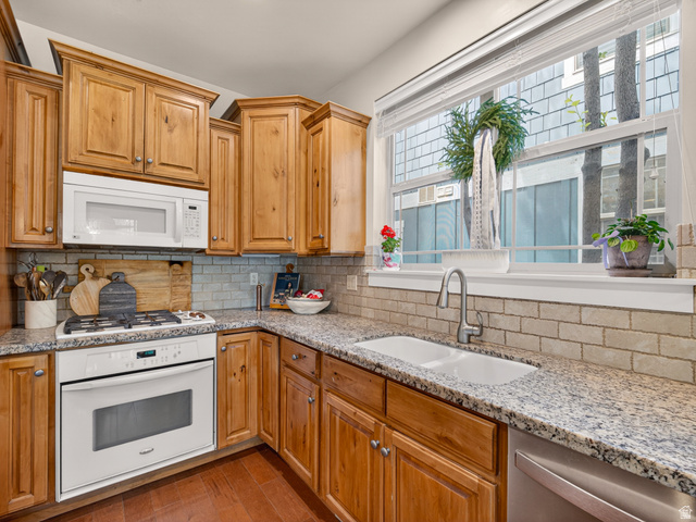 557 Craftsman Way Midway, UT 84049 - Photo 19 of 59 Kitchen featuring light wood cabinetry with crown molding, granite countertops, a built-in white microwave, and a white oven with a gas cooktop