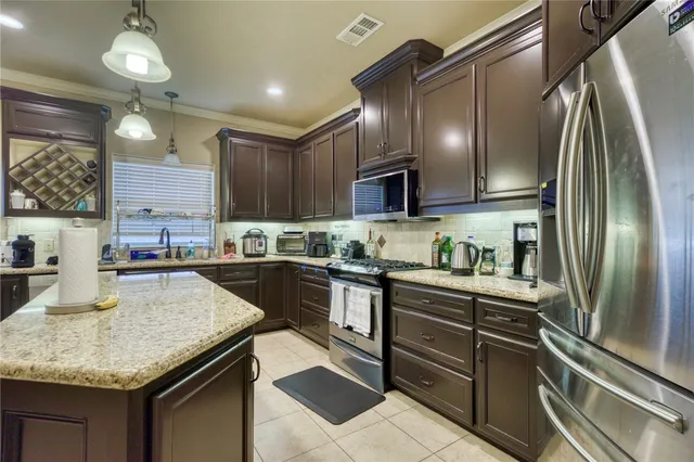 a kitchen with granite countertop stainless steel appliances and wooden cabinets