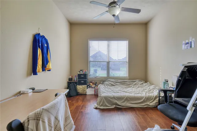 a bedroom with a bed and wooden floor