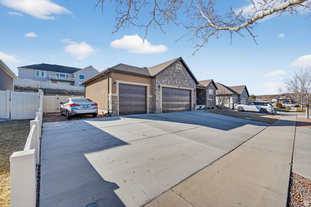 141 Wolverine Creek Elk Ridge, UT 84651 - Photo 41 of 47 View of front of property featuring stone siding, stucco siding, a gate, concrete driveway, and a residential view
