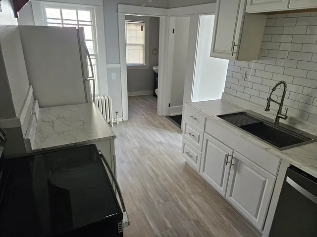 a kitchen with sink refrigerator and washing machine