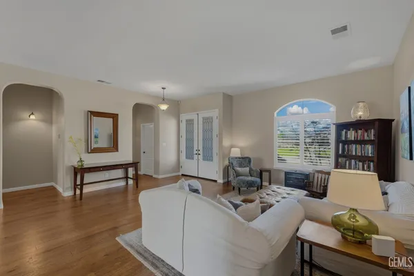 a kitchen with stainless steel appliances a sink a stove a refrigerator cabinets and chairs