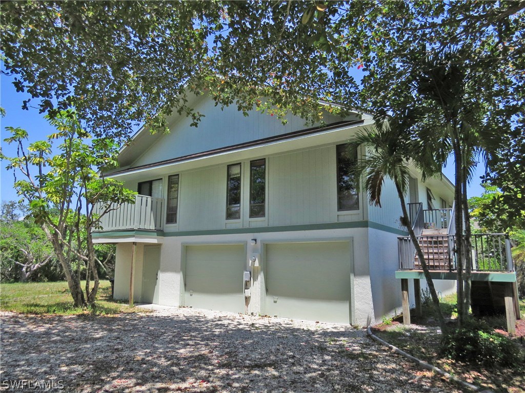 1439 Albatross Road Sanibel, FL 33957 - Photo 4 of 21 a front view of a house with a yard