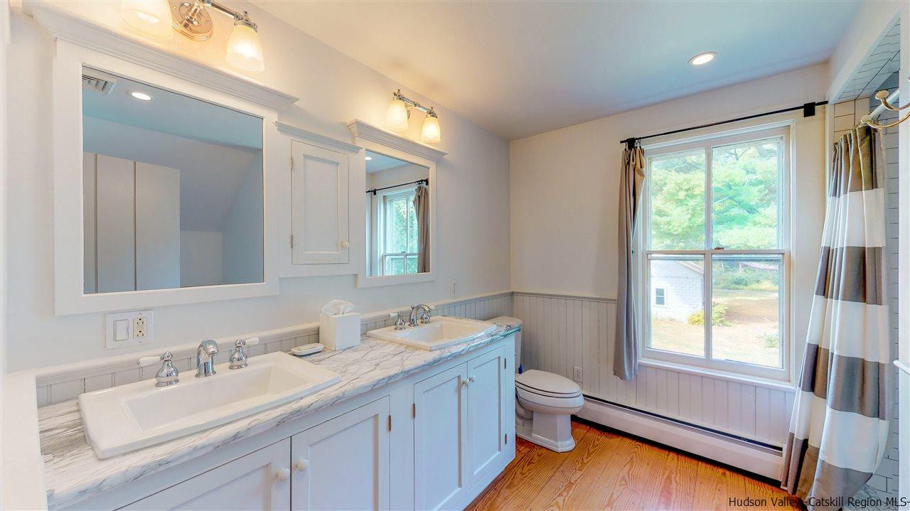 44 Peak Road Stone Ridge, NY 12484 - Photo 16 of 30 a bathroom with a granite countertop sink toilet and a large mirror