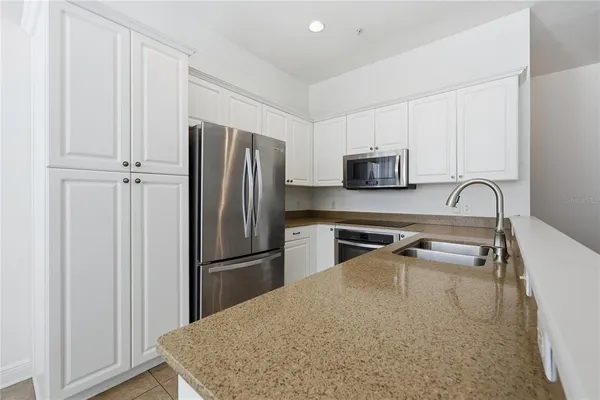 a kitchen with granite countertop a refrigerator and a sink