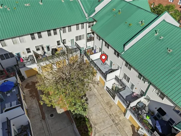 an aerial view of residential houses with outdoor space and trees