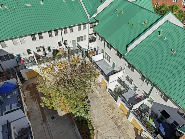 an aerial view of residential houses with outdoor space and trees