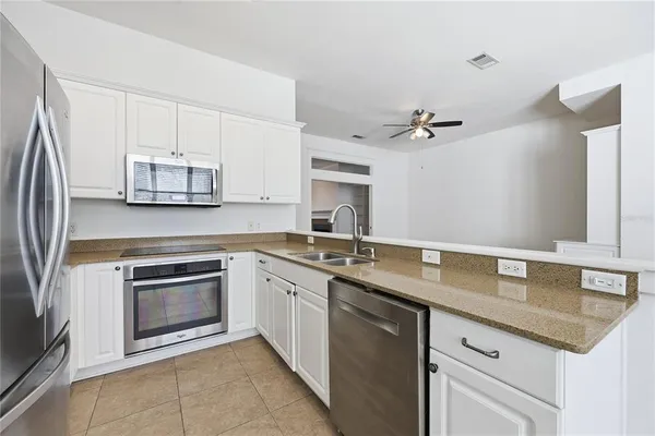 a kitchen with granite countertop a stove sink and cabinets