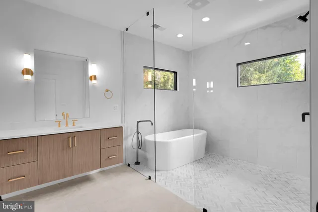 a spacious bathroom with a double vanity sink a mirror and a bathtub