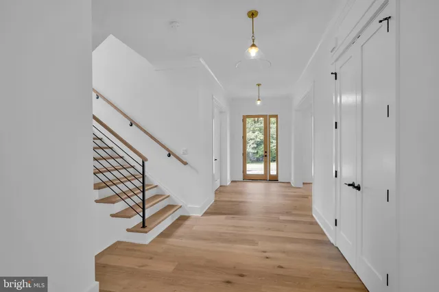 a view of a hallway with wooden floor and staircase