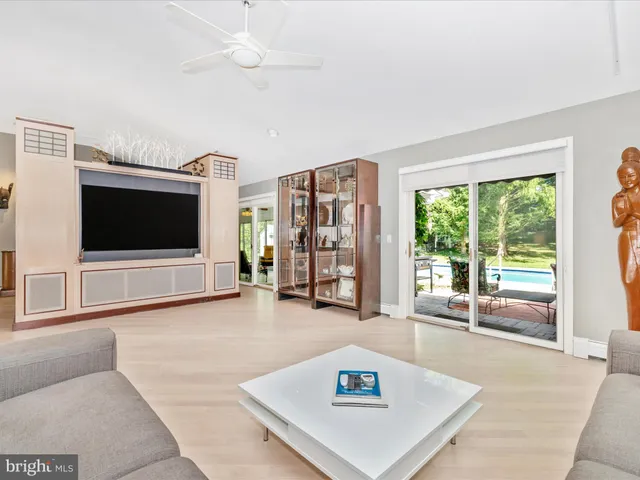a living room with patio furniture and a large window