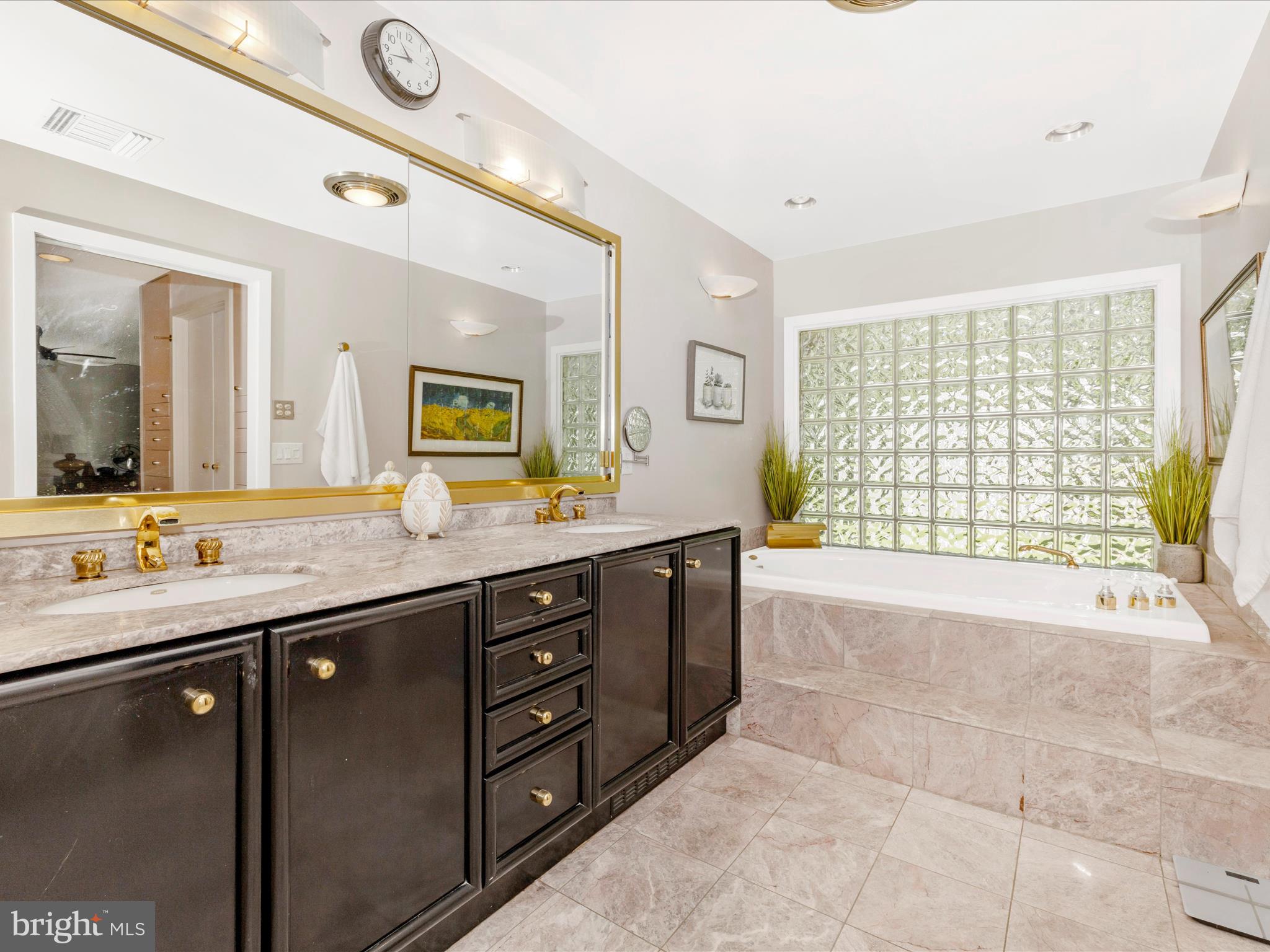 8207 Marcie Drive Baltimore, MD 21208 - Photo 39 of 67 a spacious bathroom with a granite countertop sink and a large mirror