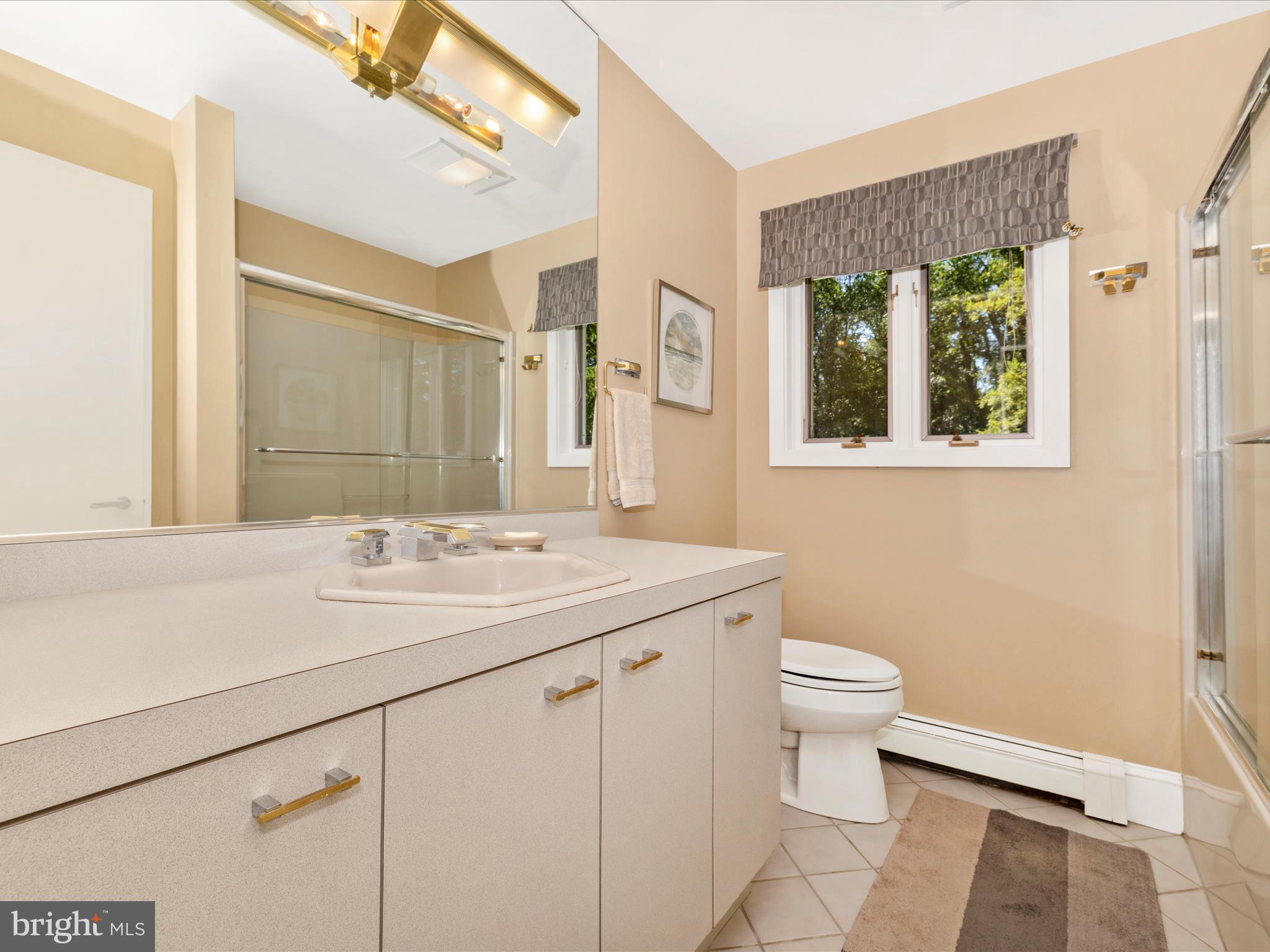8207 Marcie Drive Baltimore, MD 21208 - Photo 47 of 67 a bathroom with a sink a toilet and a mirror