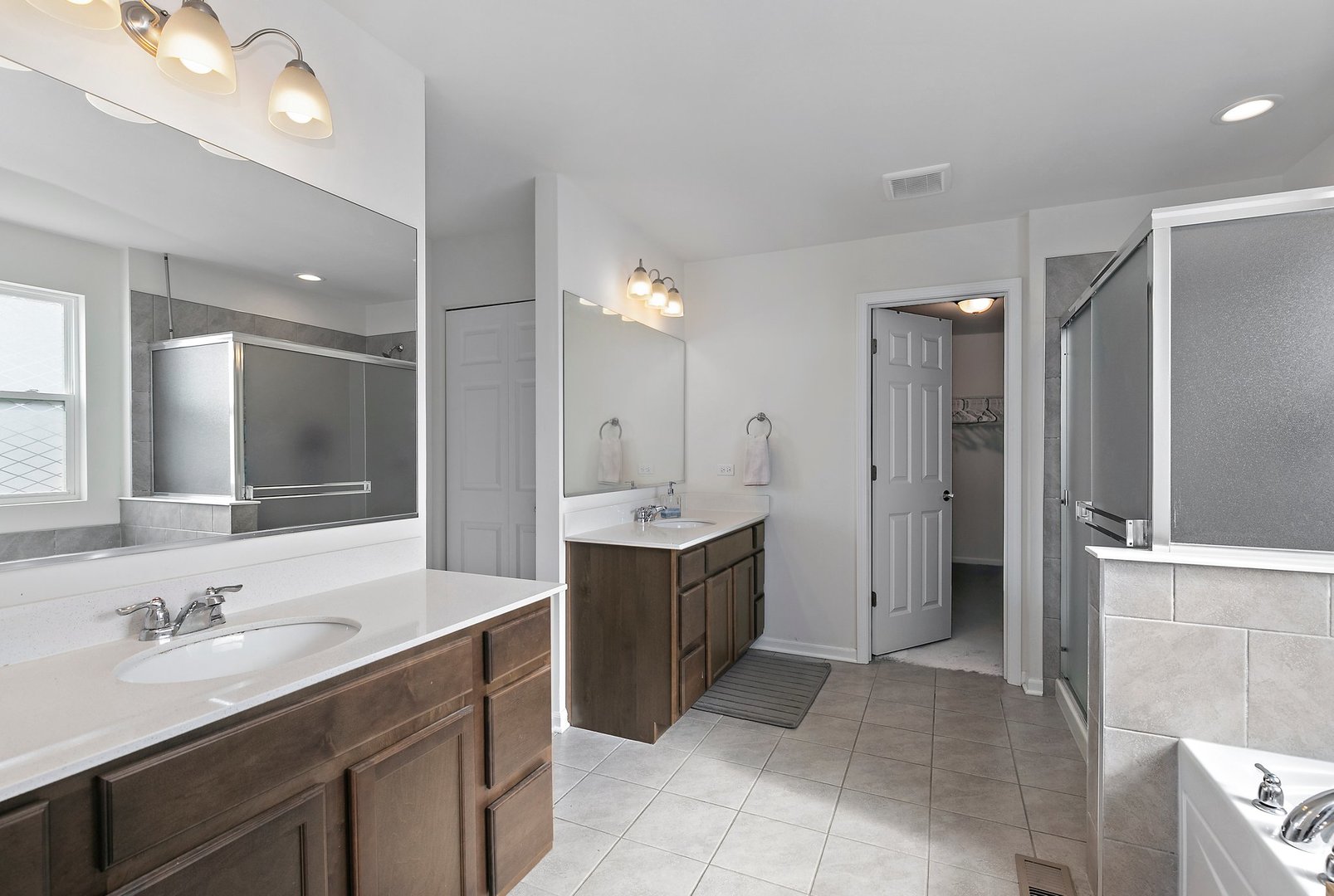 335 Snowdrop Lane Elgin, IL 60124 - Photo 17 of 25 a bathroom with a bathtub sink double vanity granite tub shower and mirror