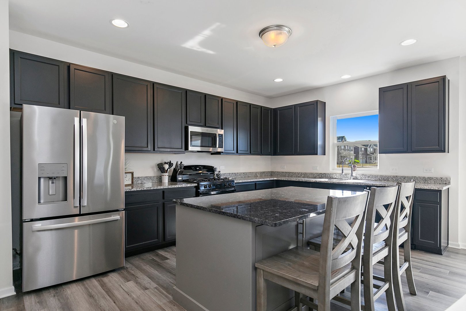 335 Snowdrop Lane Elgin, IL 60124 - Photo 7 of 25 a kitchen with granite countertop a refrigerator a sink a stove a microwave and wooden cabinets