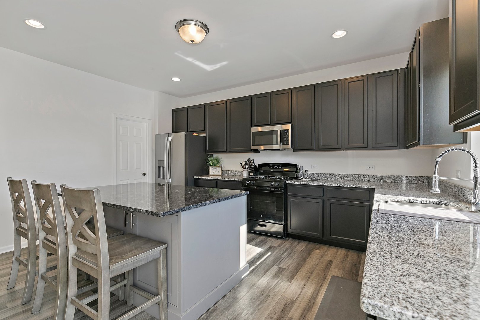 335 Snowdrop Lane Elgin, IL 60124 - Photo 9 of 25 a kitchen with stainless steel appliances granite countertop a sink stove microwave and refrigerator