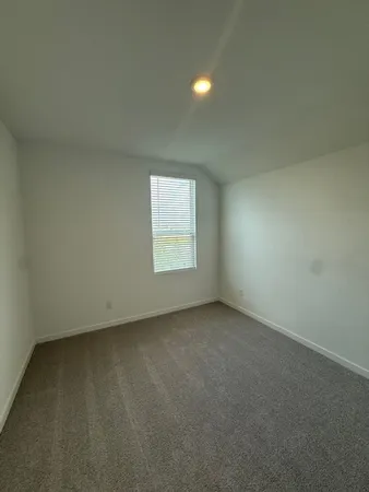 an empty room with wooden floor and a glass door