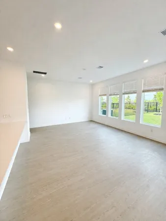 a large kitchen with stainless steel appliances a sink a stove a microwave a refrigerator and white cabinets