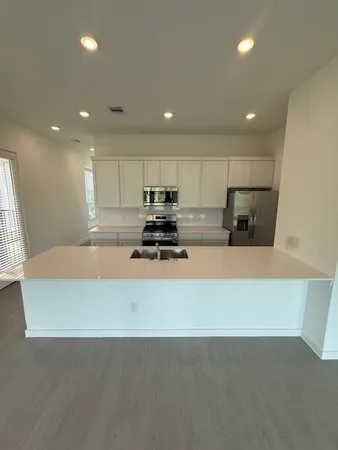 a kitchen with sink a stove and refrigerator