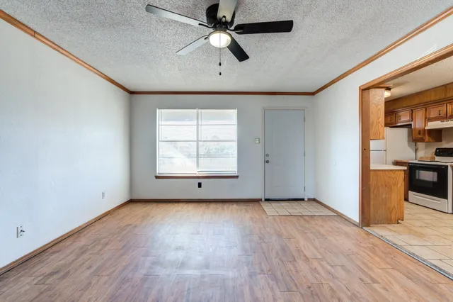 a kitchen with granite countertop a stove a sink and a refrigerator