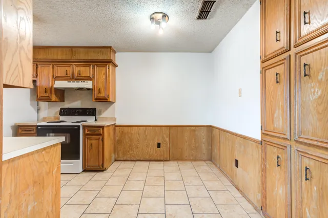 a kitchen with a stove top oven and cabinets