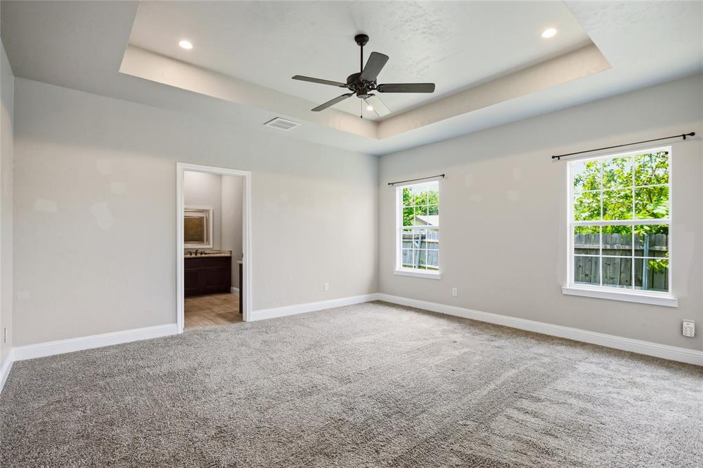 1502 Reed Street Greenville, TX 75401 - Photo 14 of 26 Spacious room featuring a tray ceiling with recessed lighting and a ceiling fan