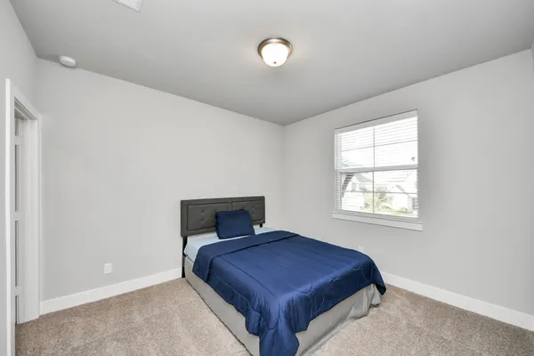 a bedroom with a bed and window