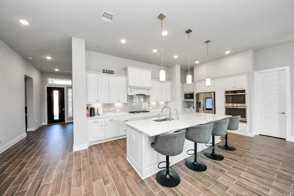 a large kitchen with kitchen island a sink table and chairs