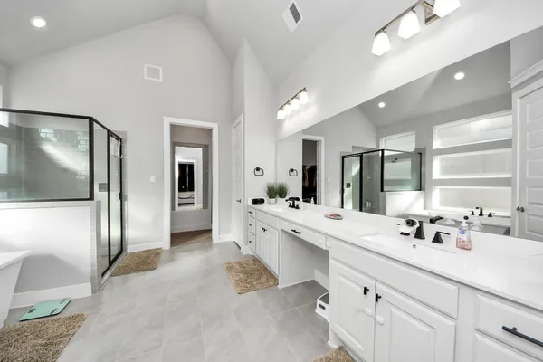 a large bathroom with a large mirror vanity and shower