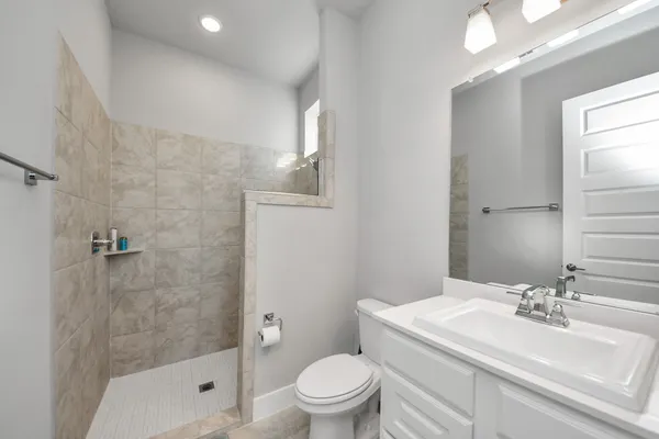 a bathroom with a sink a toilet and shower