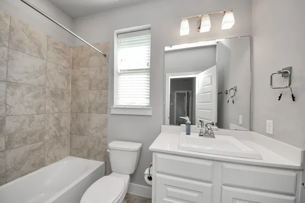 a bathroom with a sink a toilet and a mirror