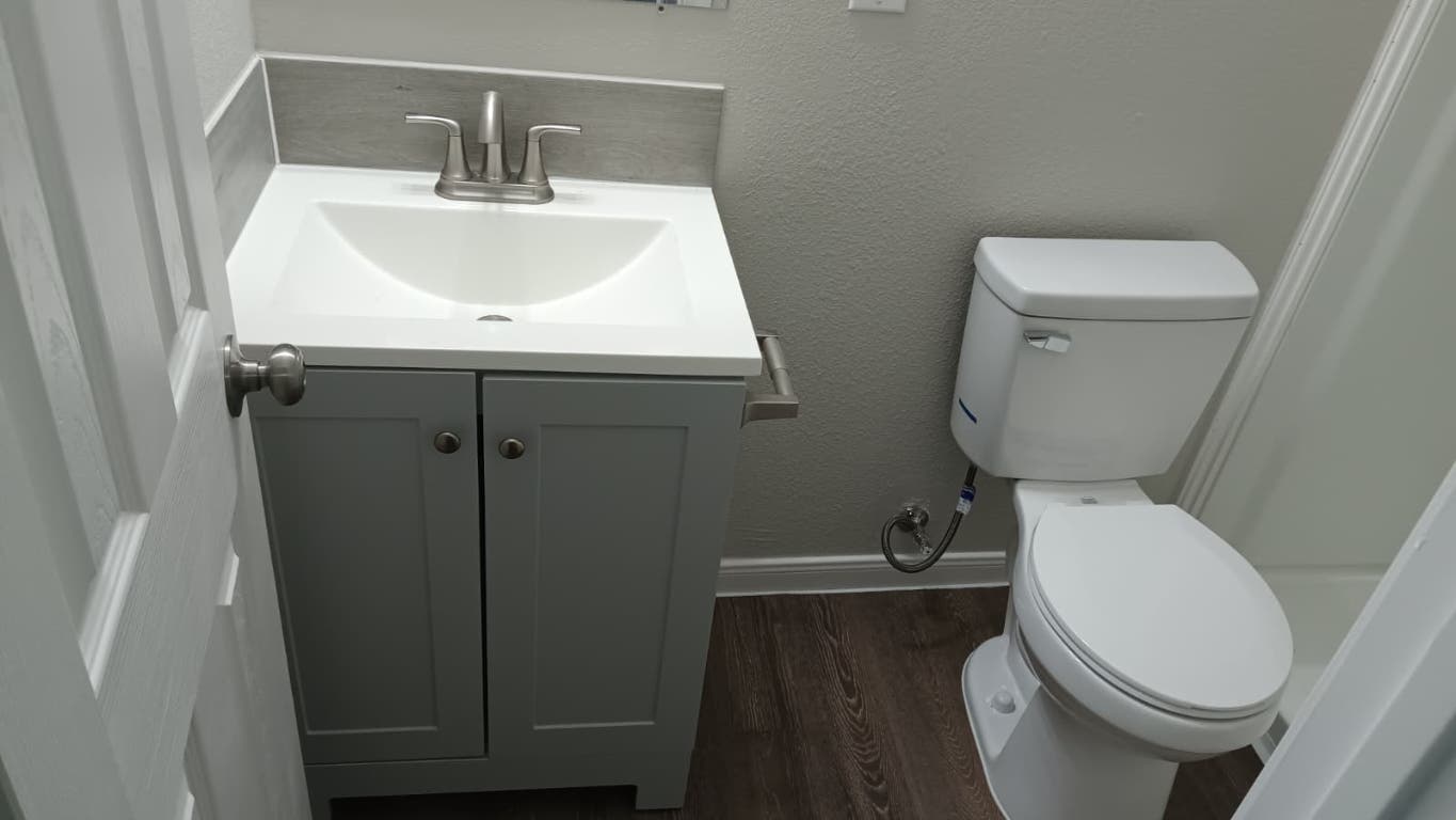 611 Carpenter Avenue, Unit 201 Austin, TX 78753 - Photo 13 of 17 a white toilet sitting next to a bathroom sink
